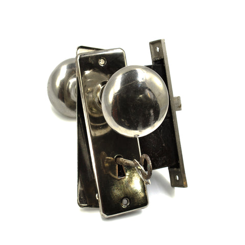 this is a vintage chromed door knob set with backplates, mortise lock and a key