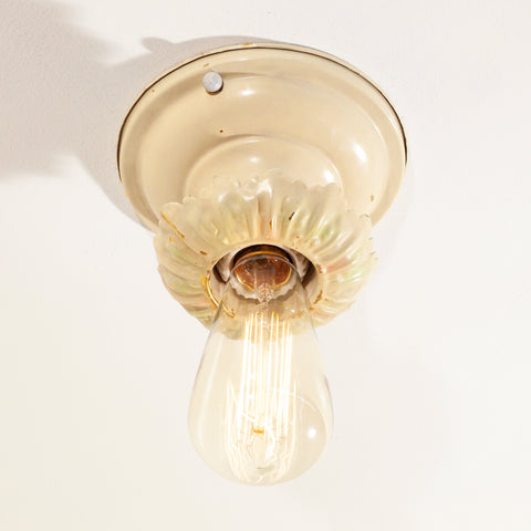 this is an antique vintage bare bulb ceiling fixture in a cream color 