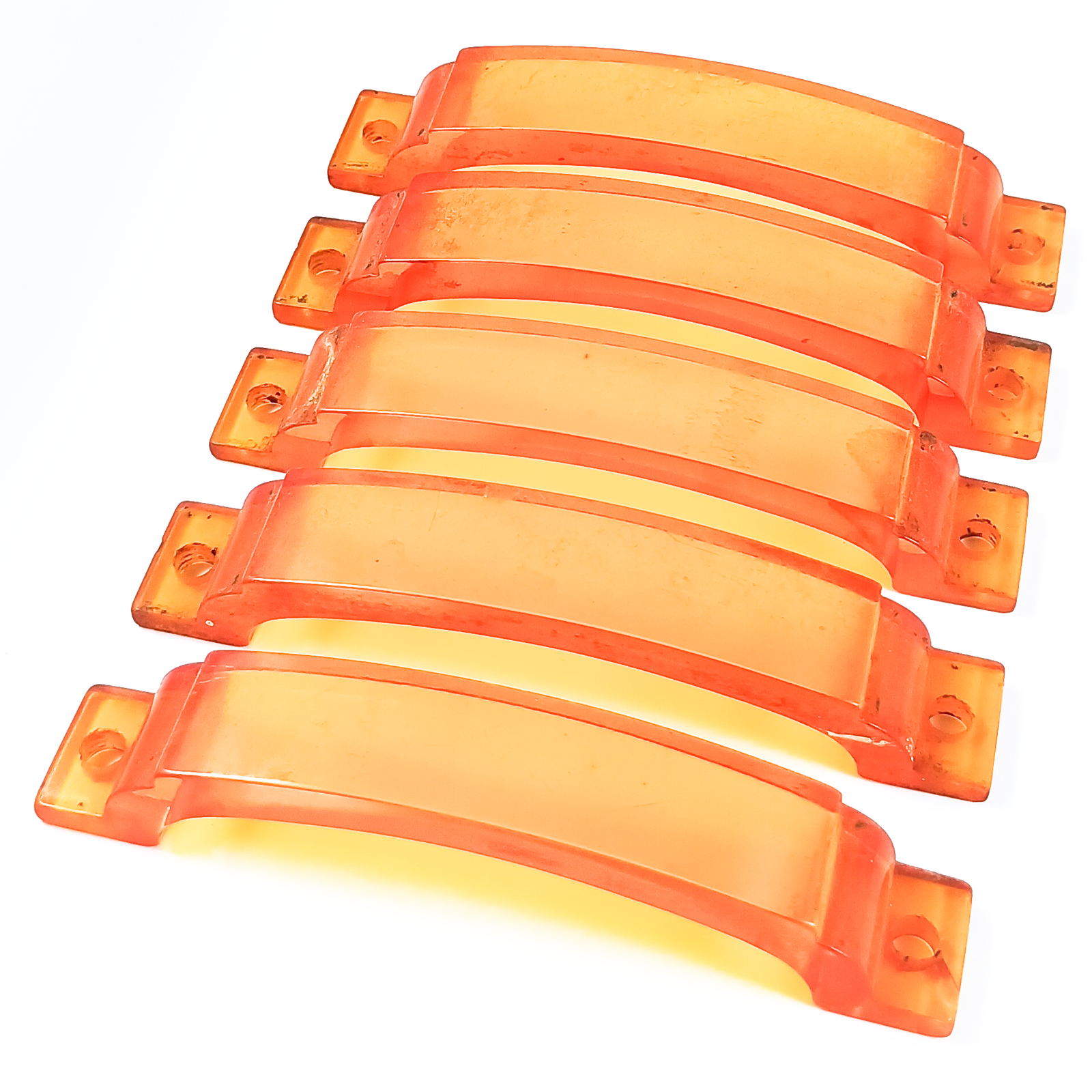 Five bright orange plastic drawer handles in good condition, though with some small dark specks of surface wear/grime.