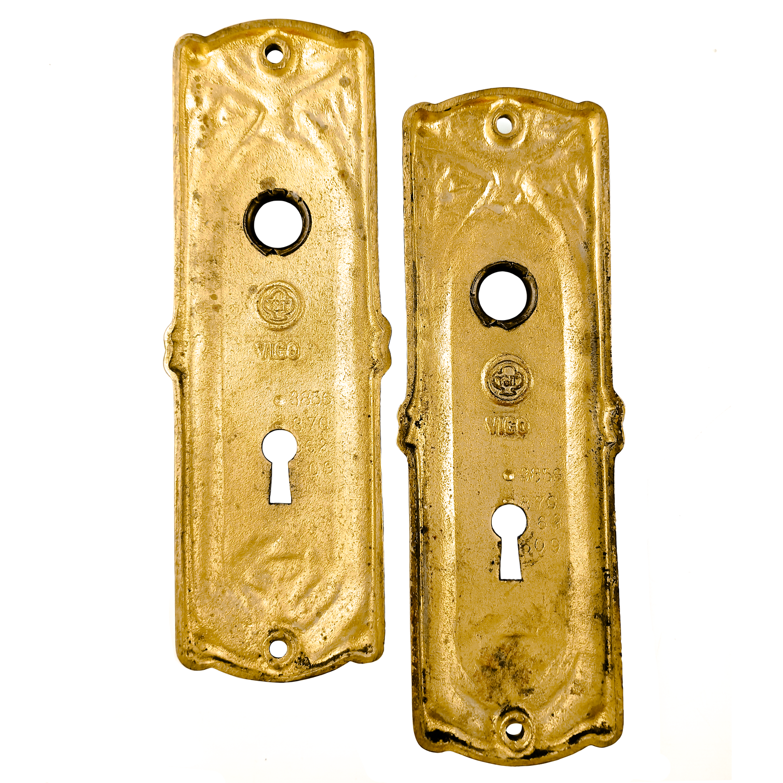 Two doorknob escutcheons, each with keyholes, fairly heavily coated in patina