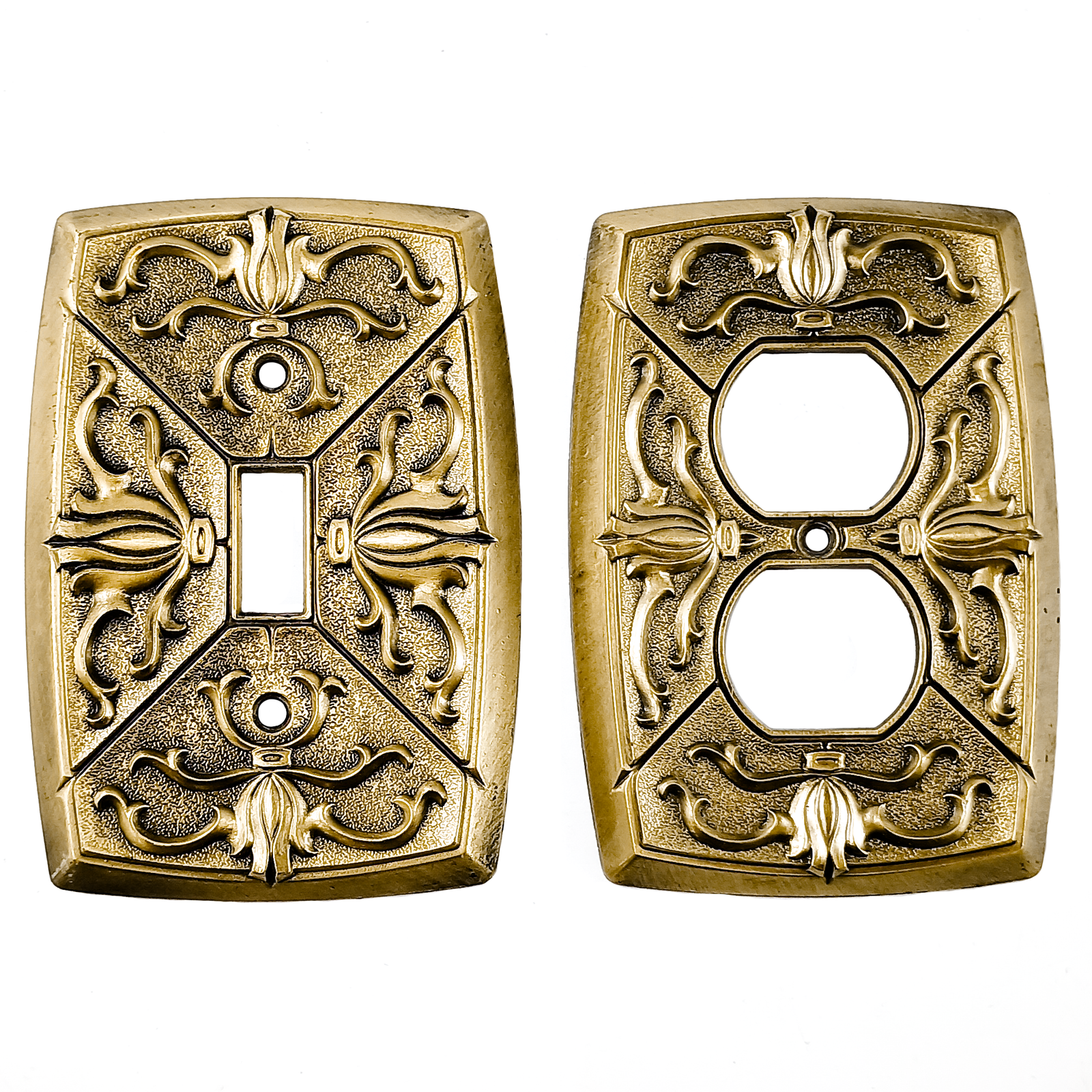 Vintage brass electrical plates with raised scrollwork designs and some patina