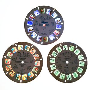 Reels labelled "Steamboat Willie," "Lonesome Ghosts," and "Finding Nemo" placed onto a light box, so the film slides are visible. Steamboat Willie is in grayscale with a greenish tint, while the other two are in full color.