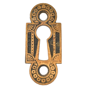 An ornate keyhole plate, with geometric details enhanced by a dark patina