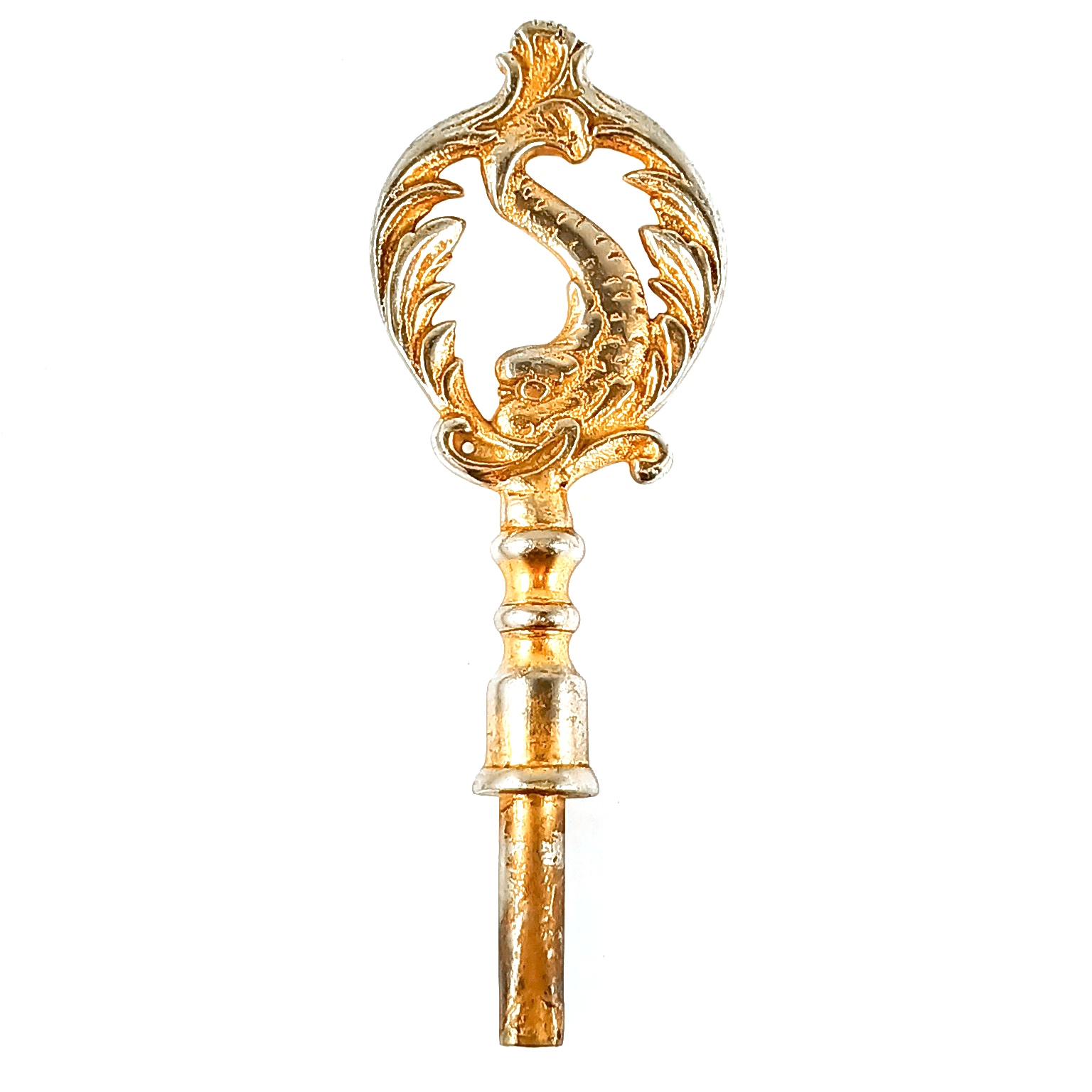 A large key consisting of a square-ended tube for the key, and a very large and ornate handle with a fish-like creature surrounded by designs shaped like cresting waves. The whole thing was originally a brassy gold tone, but you can now clearly see silver-colored metal showing through in many places.