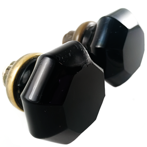 An angled shot of two black glass doorknobs with brass bases