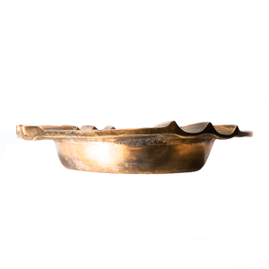 A view of the ash tray from the side, showing that the edge is rather thick but not entirely even, looking like it may have been worn down some by use