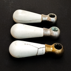 The other side view, showing that the crack on the moderately damaged cold handle goes all the way around the handle, and that there is a small chip missing from the most damaged area of the hot handle