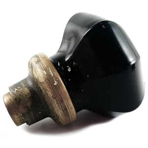A side view of the knob without the loose collar, showing some white paint flecks near and on the base