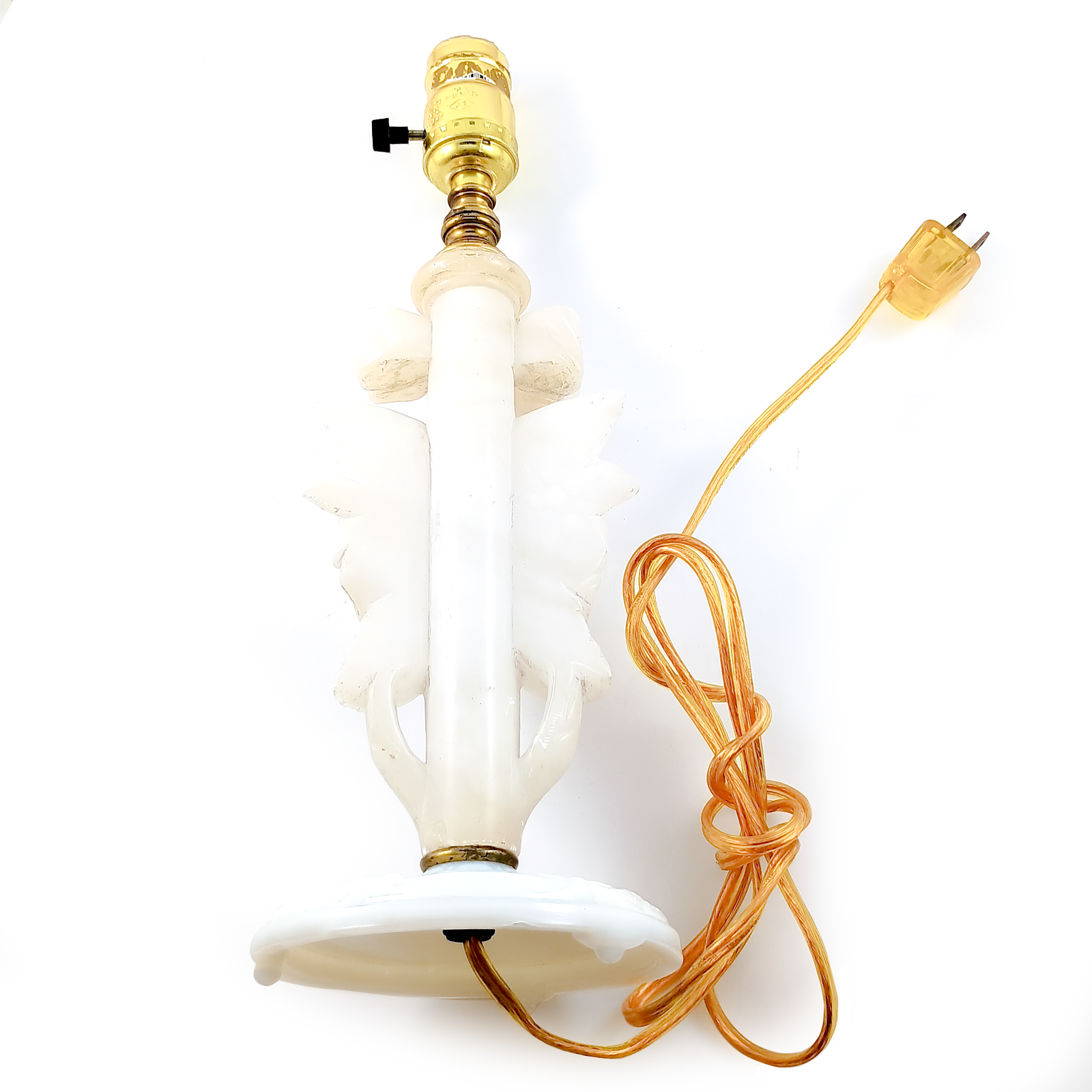 A table lamp made of carved alabaster with a glass base, a yellow corded plug, and a brass socket. The alabaster carving is in the shape of a rose with a bow above it.