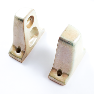 An angled view of the pieces stood up to face each other. The glaze is reflecting dark green at the corners, and the silver sheen can be seen inside the recesses of one piece