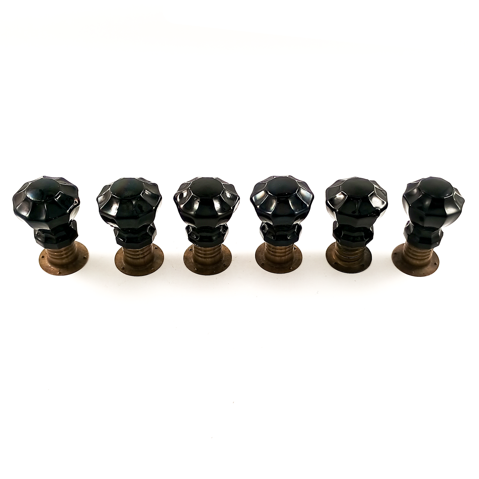 Six black glass knobs arranged in a circle on a white background. The knobs are 10-sided with fluted facets, and each appears to be sitting on a round aged bronze base.