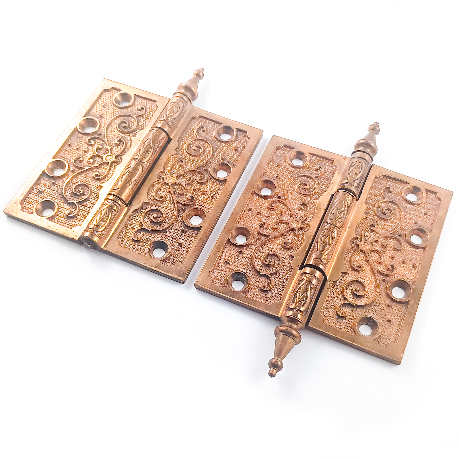 Two pairs of ornate brass hinges, one of which is missing a finial. The brass finish shows very little wear or patina.