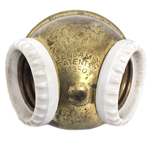 An antique brass two-socket Benjamin cluster with porcelain rings around the sockets and a patent stamp from 1903