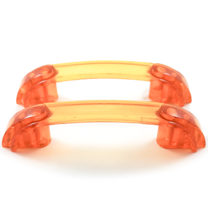 Two bright orange translucent Bakelite drawer handles, with darker orange sections at each end. Yellow patches of light on the background show the way light shines through them.