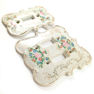 Both light switch plates, photographed at an angle so the light shining off the gilding is more visible