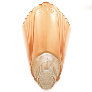 An orange glass slip shade with a partially scalloped edge and a clear portion with a pressed starburst at the base