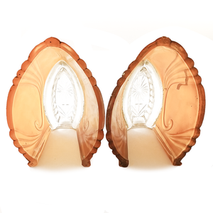 Two orange and clear glass slip shades, showing the interiors of the shades and the hand-ground, partially scalloped rims. One shade has a sizeable crack in one side.