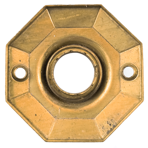 The back of an octagonal brass rosette, with some surface wear and scratches.