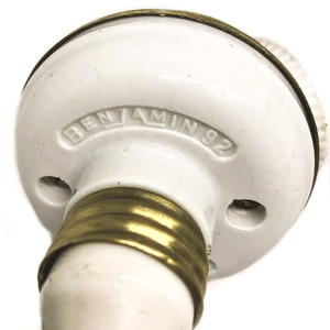 The back of an antique two-socket Benjamin cluster, cast in porcelain and brass and stamped BENJAMIN 92
