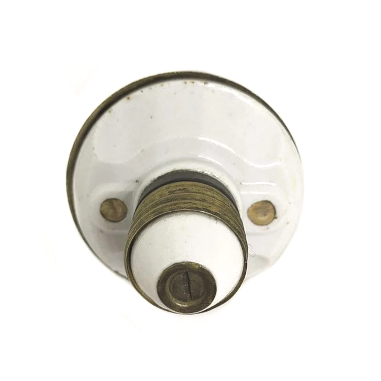 An antique brass two-socket Benjamin cluster with porcelain rings around the sockets and a patent stamp from 1903