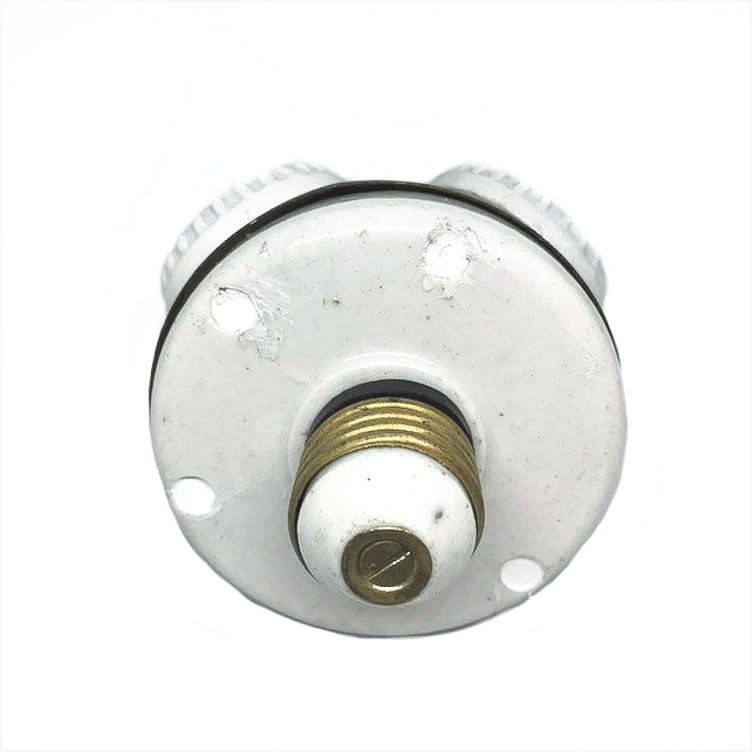 A brass ball with four white ceramic rings on it, each surrounding a light socket