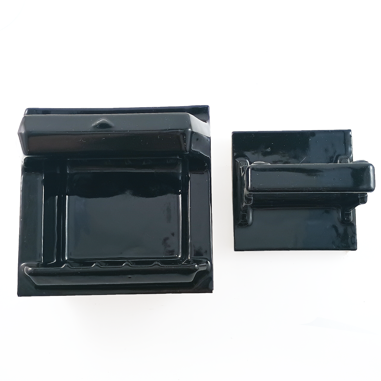 A head-on view of a soap holder with a grab bar and a cup holder, both tile-in. Both are porcelain, glazed in glossy black. The angle means you can only see the side of the cup holder, obscuring what it is.