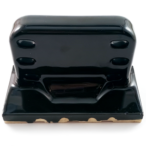 The underside of a wall-mounted porcelain toothbrush holder, glazed in glossy black