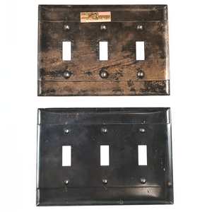 The backs of both plates.The darker plate has an even black coating on the back, with some minor scratches. The lighter plate looks like it previously had the same black finish, but it was partially removed. The lighter plate has a shiny golden sticker on the back.
