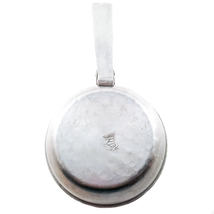 The underside of the silent butler, which is mostly smooth but shows some evidence of being hammered as well. The Canterbury logo stamp appears again, slightly off-center, on the bottom of the bowl portion.