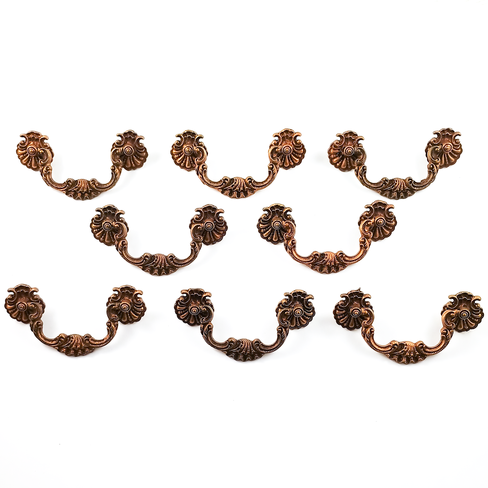 Eight patina-coated brass drawer pulls consisting of two shell-shaped rosettes and a center handle with scroll work and a shell shape in the middle