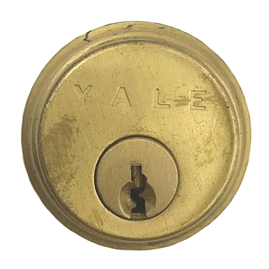 A vintage brass Yale cylinder lock on top of its red original box, alongside a pair of keys
