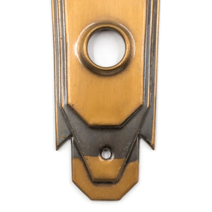 A close-up of the doorknob hole of a bronze Art Deco escutcheon
