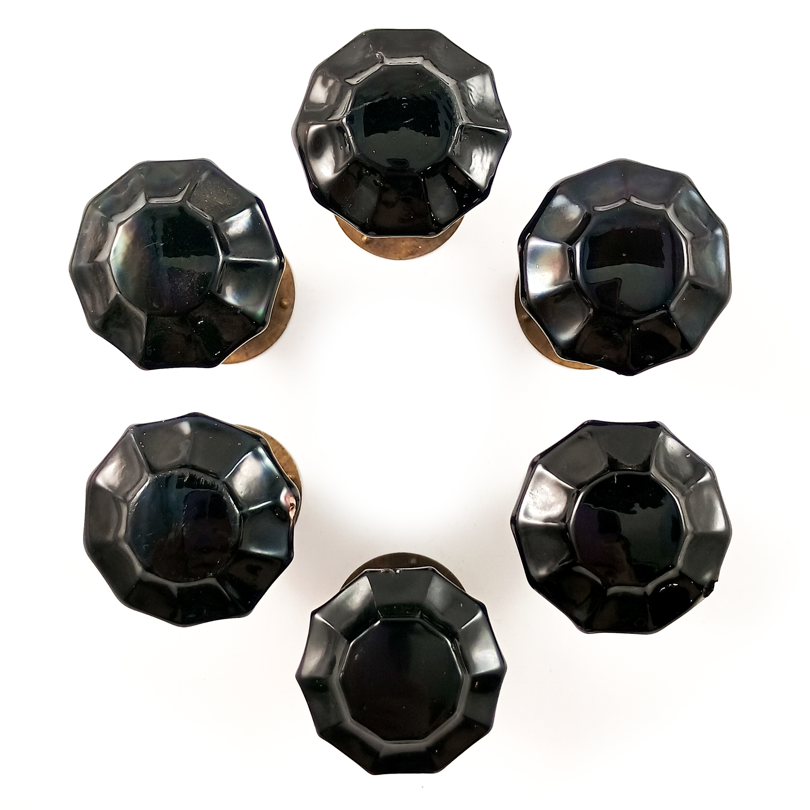 Six black glass knobs arranged in a circle on a white background. The knobs are 10-sided with fluted facets, and each appears to be sitting on a round aged bronze base.