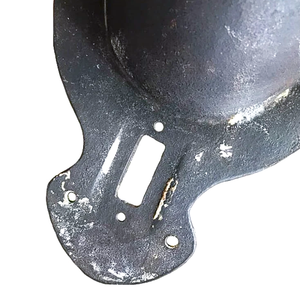 A close-up of the back of an antique iron wall sconce, showing some surface wear
