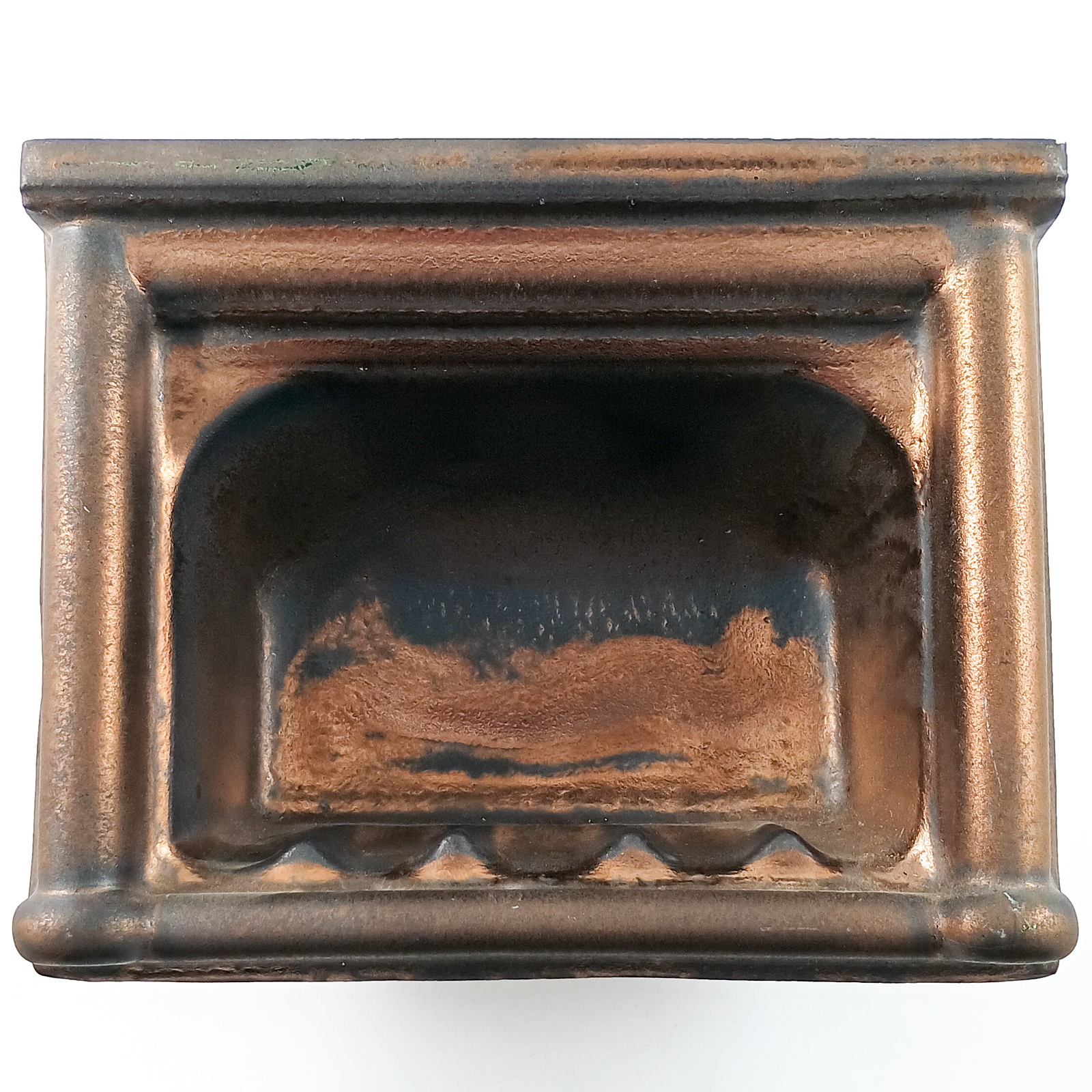 A wall-mounted porcelain soap dish glazed in a mix of matte grey-brown and metallic copper