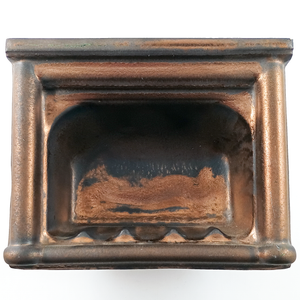 A wall-mounted porcelain soap dish glazed in a mix of matte grey-brown and metallic copper
