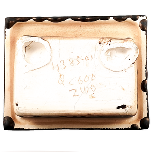The back of a wall-mounted porcelain soap dish, which is unglazed porcelain and has been written on in brown pencil, reading "4385-01 C600 2100"