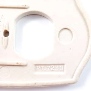 A close-up of the back of the outlet plate, showing the stamp more clearly. It reads "PT. 7230"
