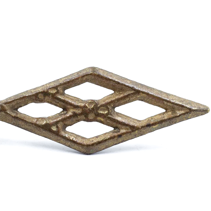 A vintage brass finial in the shape of four diamonds, forming a larger overall diamond shape