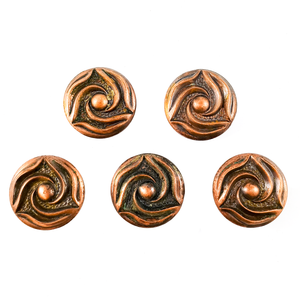 Five round copper cabinet knobs with three-pointed swirl designs, arranged in two rows