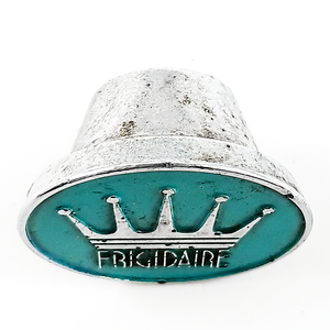A side view of a chrome and enamel knob depicting the Frigidaire logo with a large crown. The side of the knob shows a moderate amount of wear to the chrome finish.