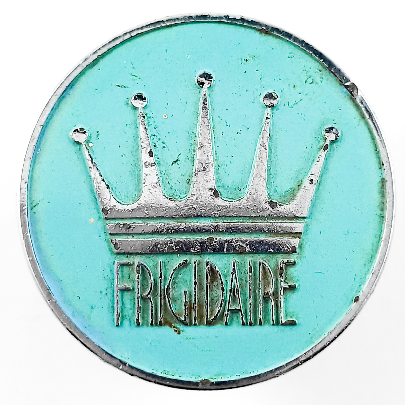 A round turquoise and chrome knob depicting the Frigidaire logo, along with a large five-pointed crown