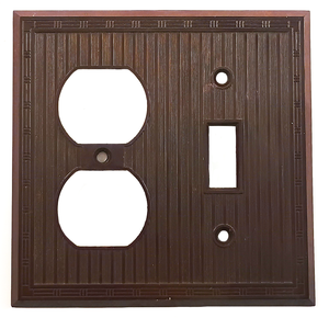 A photo of a square, dark brown plastic wall plate, with openings for two electrical outlets and one light switch. It has a ribbed texture and a decorative geometric border around the edge.