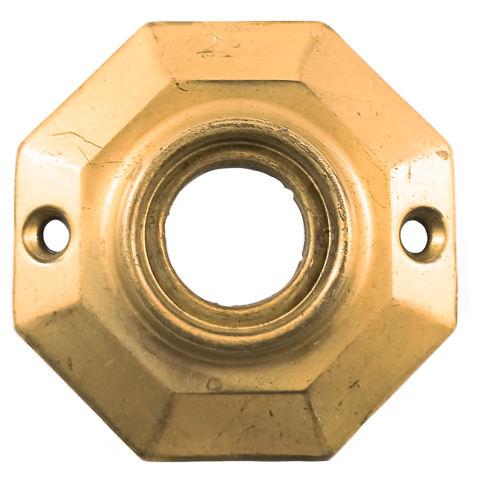 An octagonal brass rosette, with a hole in the middle for a doorknob and two screw holes oriented horizontally. The surface is somewhat scratched.