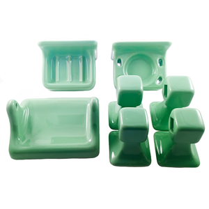 A set of light blue-green porcelain pieces against a white background. There is a soap dish, a toothbrush holder with an indentation for a cup in the middle, a toilet paper roll holder, and four end pieces to hold two towel racks. All items are designed to be mounted to a wall.