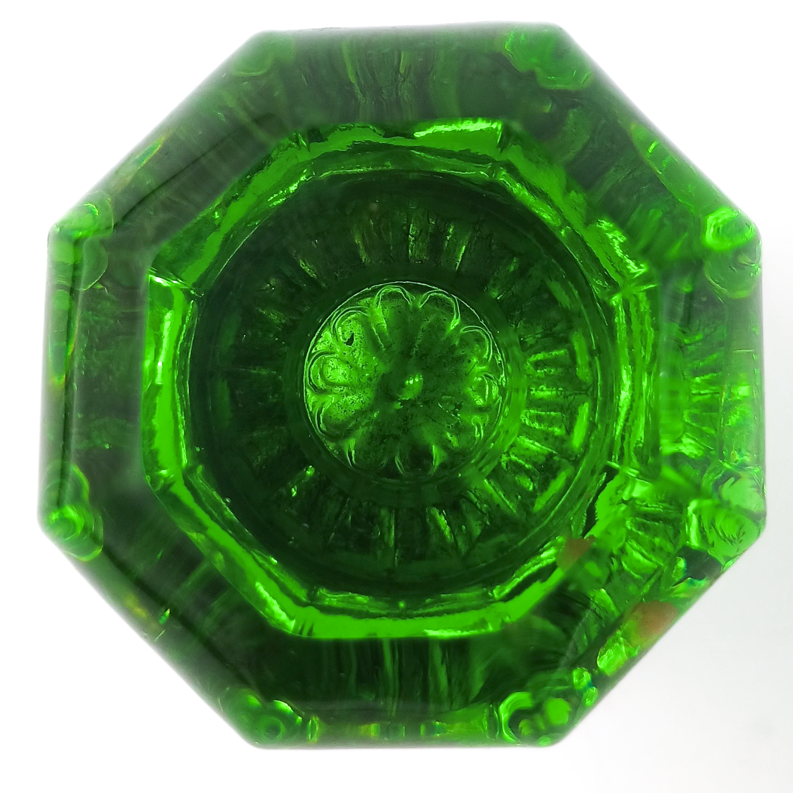 A head-on photo of a green glass octagonal doorknob, with a flower shape in the middle
