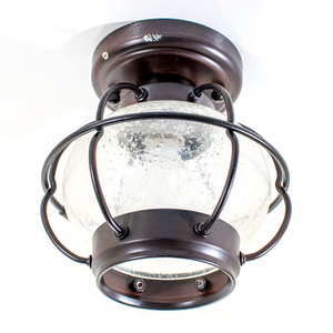 An industrial-style ceiling-mounted light fixture shaped like a lantern, with dark bronze-finished metal and bubbly clear glass