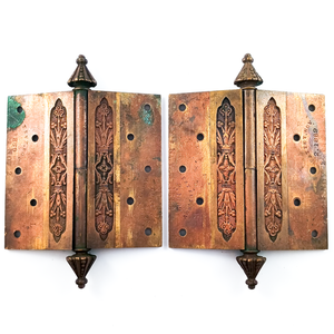 The inner faces of the same hinges. Near the pivot of the hinge, there is a thin design that is similar to the floral design on the outer faces of the hinges. The rest of the inner face is smooth, with patent stamps on each plate. There is more verdigris here, as well as the same amount of patina, and some slight scratches.