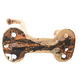 The base of a large antique coat hook, which had paint and some rust on it and shows four screw holes