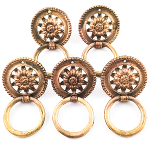 Five vintage brass ring pulls with beaded edges and sunflowers in the middle. The rings are flipped down, showing that the backs of the rings are undecorated.
